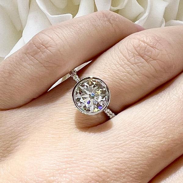 White gold with a large diamond on a hand against a white fabric background